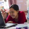 Young Asian woman video conferencing on her laptop in her house